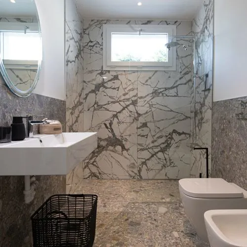 Bagno della dependance con pavimento in gres effetto Ceppo di Gré e rivestimento effetto marmo